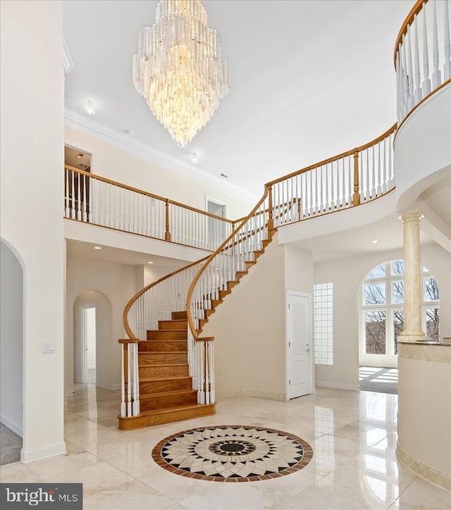 foyer with stairway, arched walkways, a towering ceiling, and marble finish floor