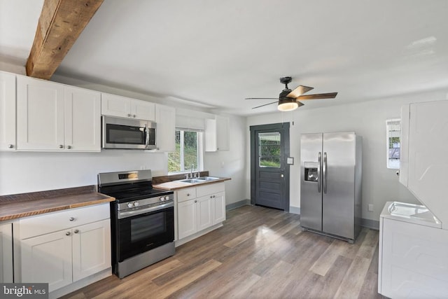 kitchen featuring stainless steel appliances, white cabinetry, sink, and hardwood / wood-style floors