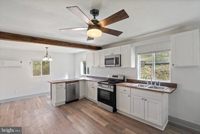 kitchen with appliances with stainless steel finishes, sink, and white cabinets