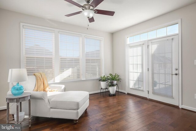 living area with dark hardwood / wood-style flooring and ceiling fan