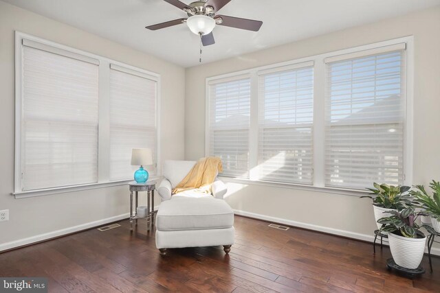 living area featuring dark hardwood / wood-style flooring and ceiling fan