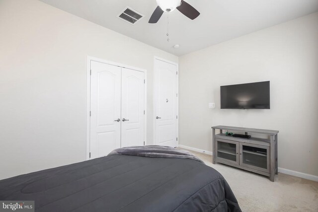 unfurnished bedroom with ceiling fan, light carpet, and a closet