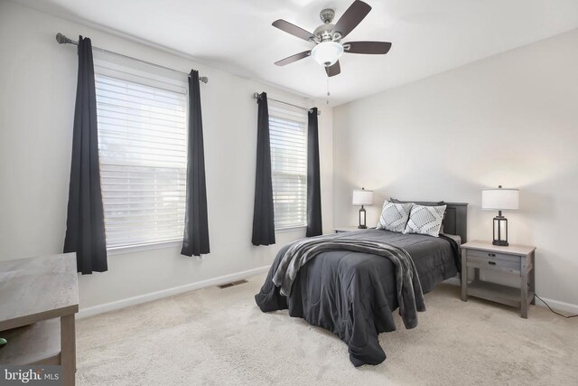 bedroom with ceiling fan and light carpet