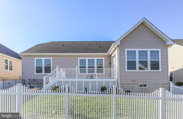 rear view of house featuring a lawn