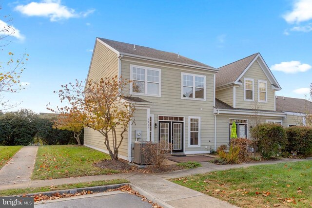 view of front of property with a front yard and central air condition unit