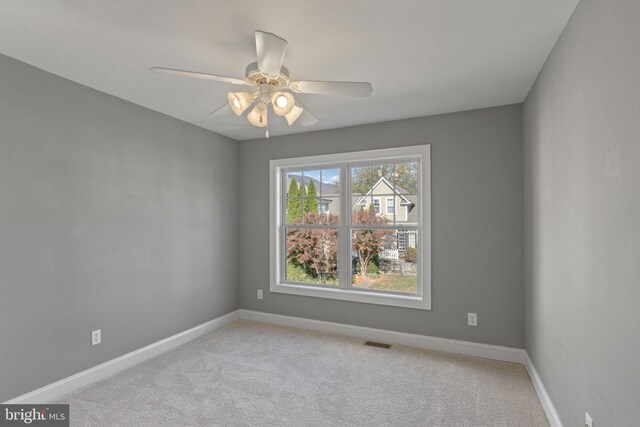 carpeted spare room featuring ceiling fan