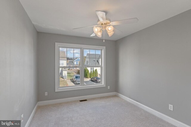 carpeted spare room with ceiling fan