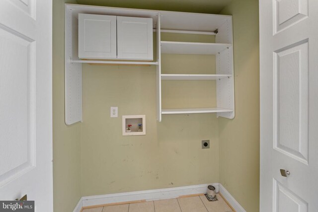 washroom with washer hookup, cabinets, hookup for an electric dryer, and light tile patterned flooring