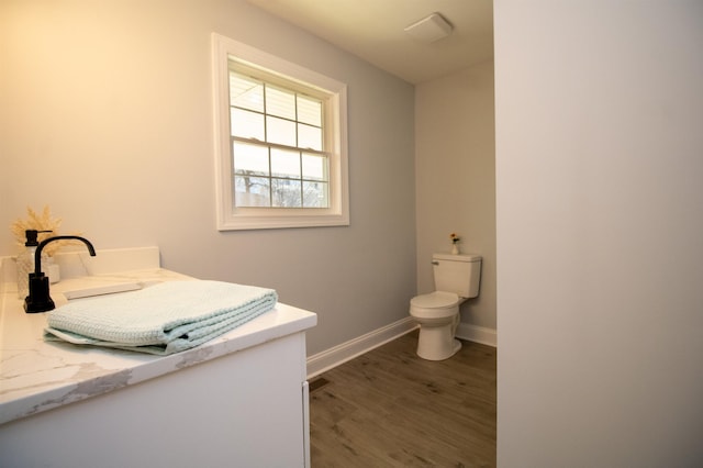 bathroom with vanity, toilet, and hardwood / wood-style floors