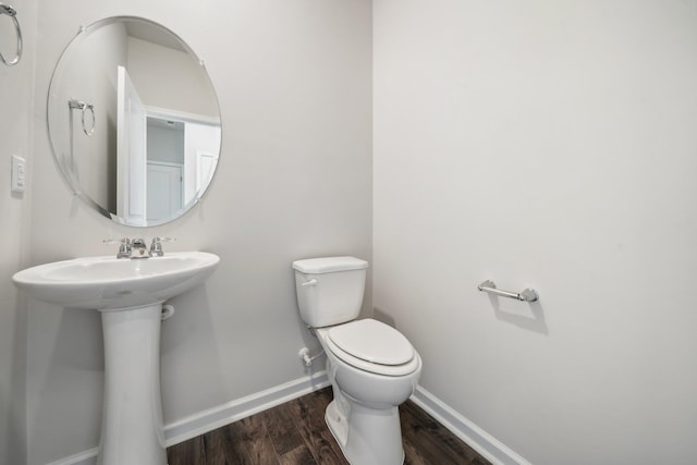 bathroom featuring toilet, baseboards, and wood finished floors