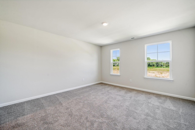 spare room with baseboards and carpet