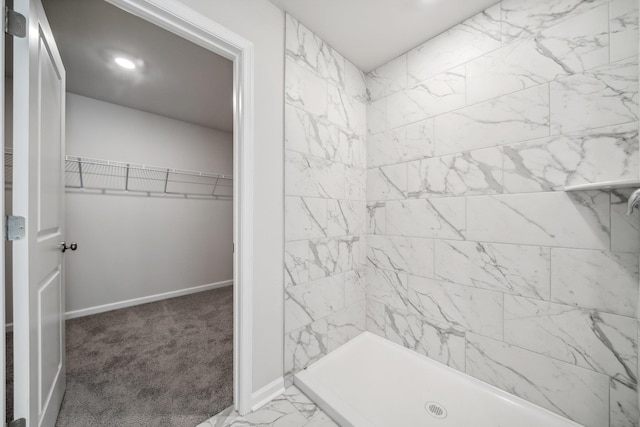 full bathroom with a spacious closet, baseboards, a stall shower, and marble finish floor