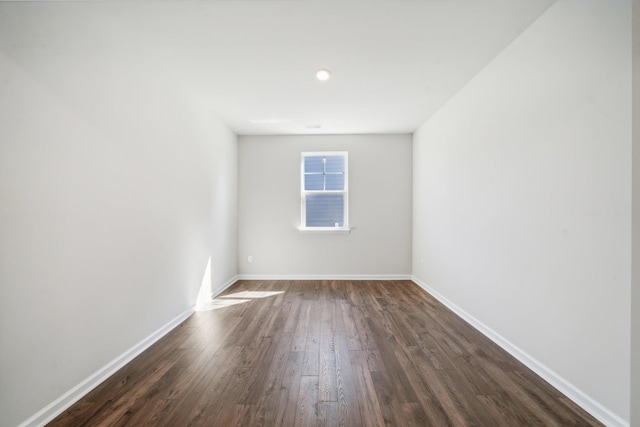 empty room with dark wood finished floors and baseboards