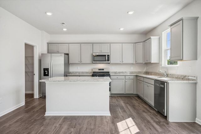 kitchen with stainless steel appliances, gray cabinetry, and a center island