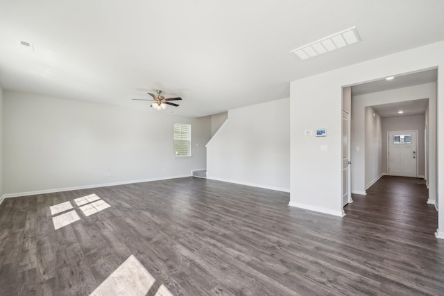 unfurnished living room featuring visible vents, baseboards, dark wood-type flooring, and a ceiling fan