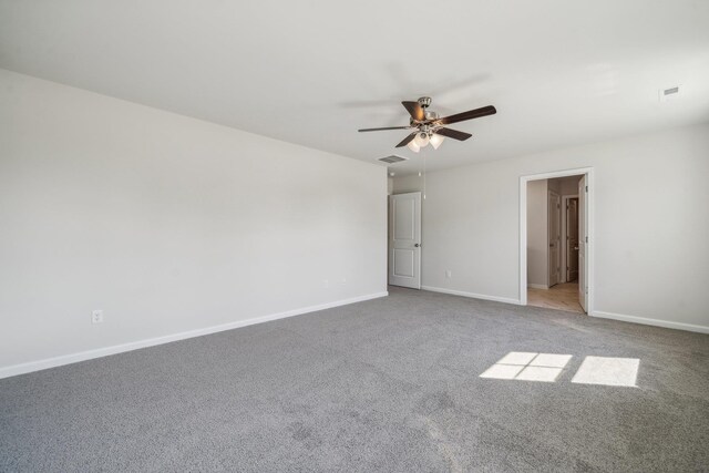 unfurnished bedroom featuring carpet flooring, visible vents, baseboards, and ceiling fan