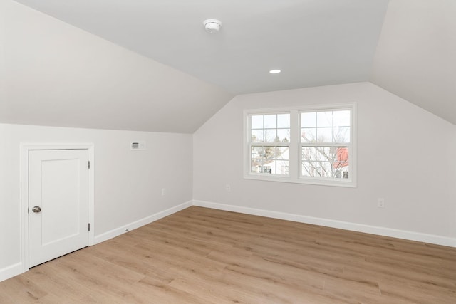 bonus room with lofted ceiling, baseboards, visible vents, and light wood-type flooring