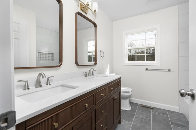 bathroom featuring a sink, visible vents, toilet, and double vanity