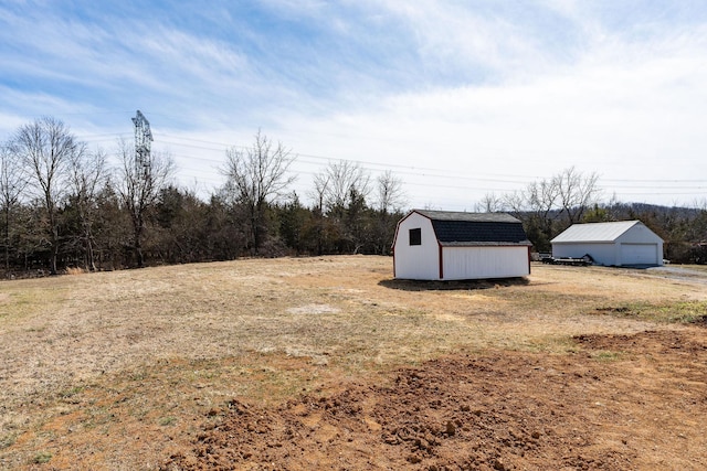 view of yard featuring an outbuilding, a storage unit, and a garage