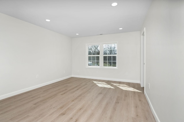 spare room featuring recessed lighting, light wood-type flooring, and baseboards