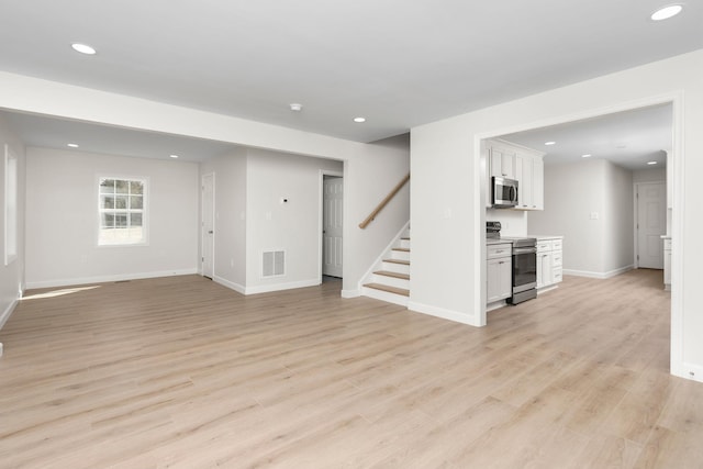 unfurnished living room with visible vents, recessed lighting, stairway, and light wood-style floors