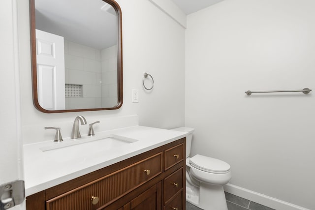 bathroom with baseboards, toilet, vanity, and tile patterned flooring