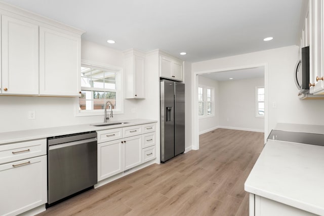 kitchen with stainless steel appliances, light countertops, and a sink