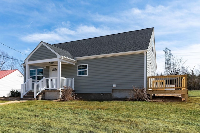 bungalow-style house with covered porch, a front yard, and a shingled roof