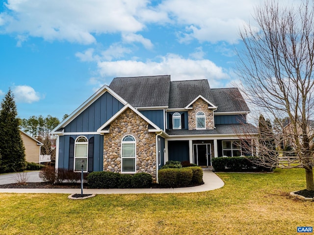 view of front of house featuring board and batten siding, a front lawn, and a shingled roof