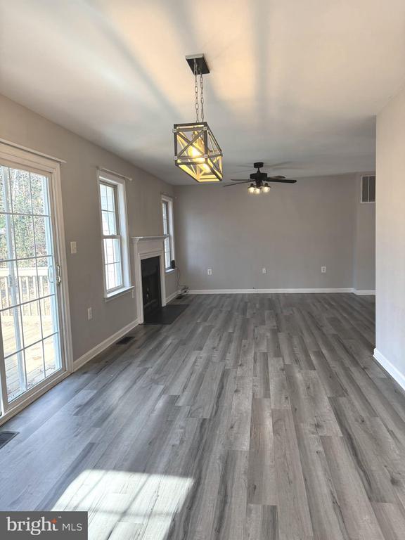 unfurnished living room with ceiling fan and dark hardwood / wood-style flooring