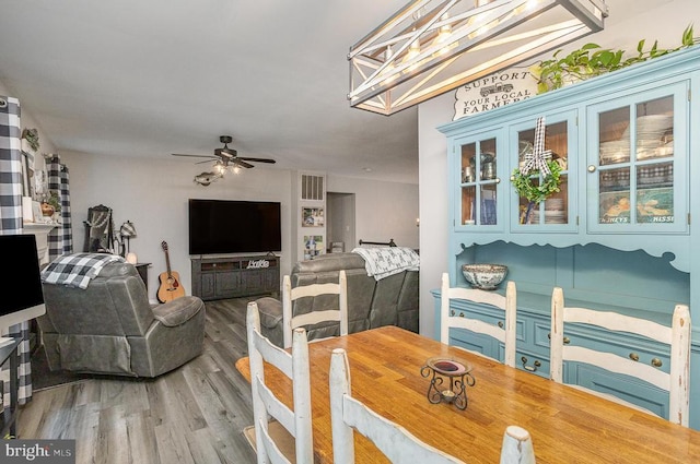 dining area with ceiling fan and wood-type flooring