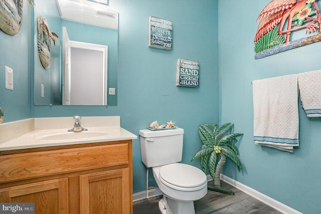 bathroom featuring vanity, wood-type flooring, and toilet