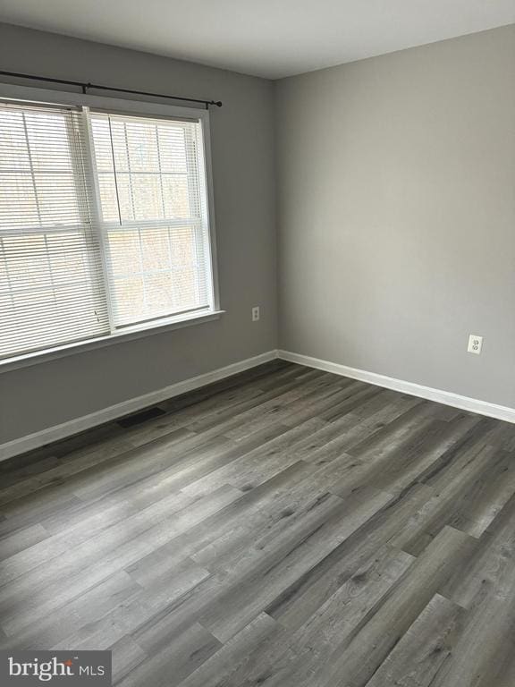 spare room with dark hardwood / wood-style flooring