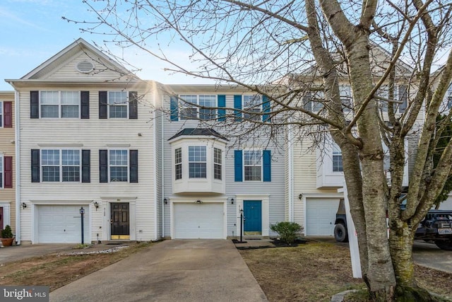 townhome / multi-family property featuring driveway and a garage