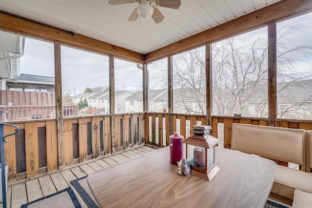 sunroom featuring ceiling fan and a residential view