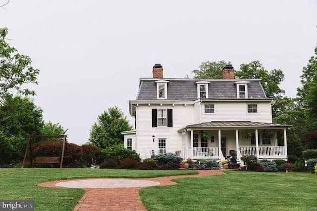 view of front of property with covered porch and a front lawn