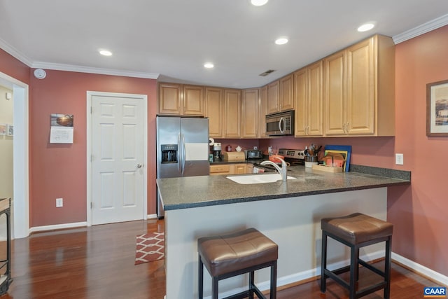 kitchen featuring a breakfast bar area, recessed lighting, a peninsula, dark wood-style flooring, and appliances with stainless steel finishes