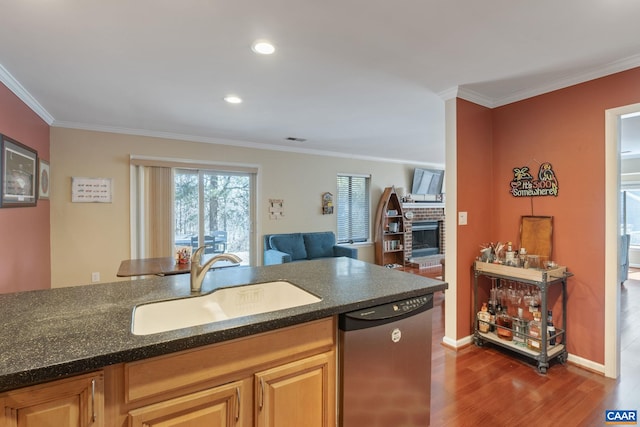 kitchen featuring a sink, dark wood-style floors, ornamental molding, a brick fireplace, and dishwasher