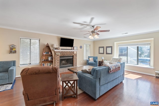 living area with ornamental molding, wood finished floors, and baseboards