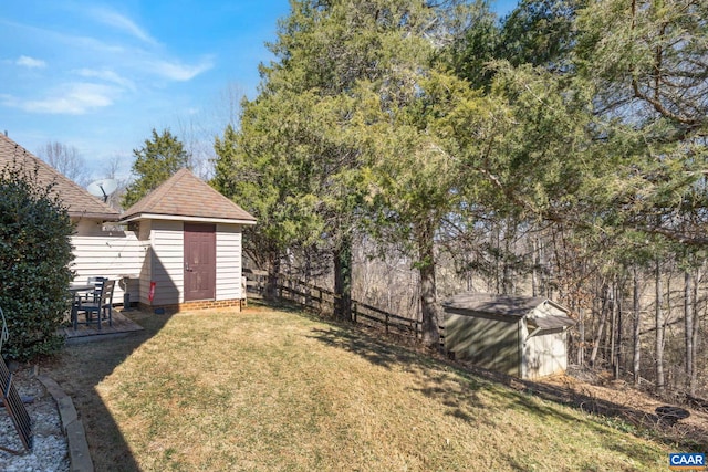 view of yard with an outbuilding, fence, and a storage shed