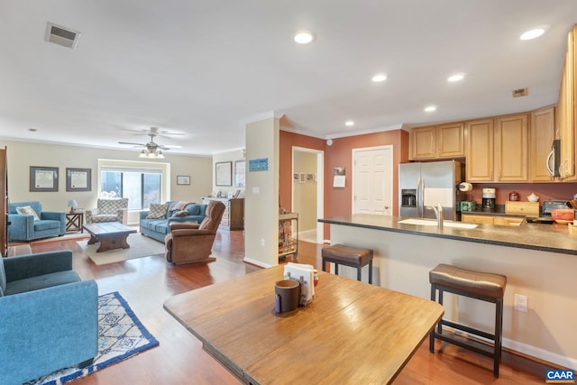 dining space with crown molding, light wood finished floors, recessed lighting, visible vents, and baseboards