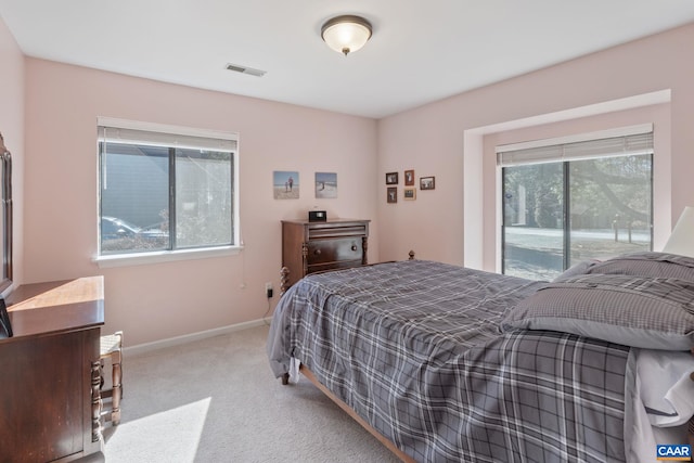 carpeted bedroom featuring access to outside, visible vents, and baseboards