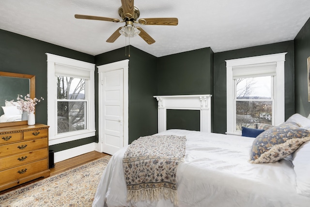 bedroom featuring a ceiling fan, wood finished floors, and baseboards