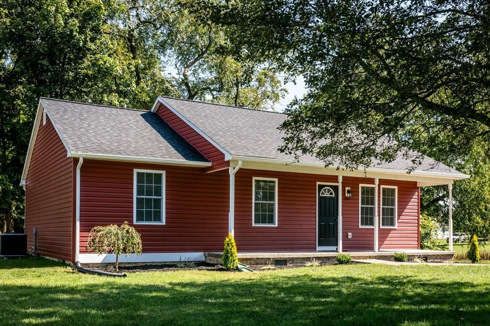 view of front of property featuring central AC unit and a front lawn