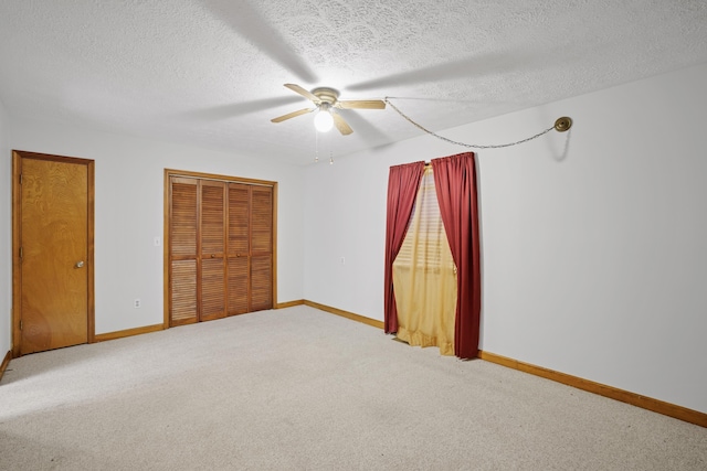 unfurnished bedroom with carpet floors, a textured ceiling, ceiling fan, and a closet