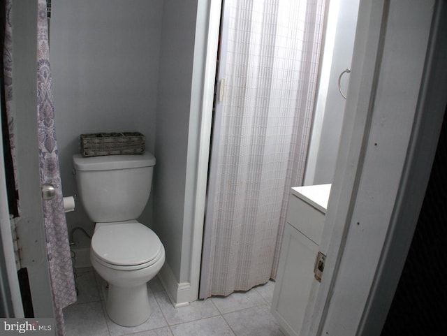 bathroom with toilet, tile patterned flooring, and vanity