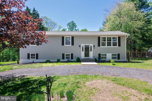 bi-level home with fence and a front lawn