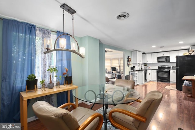 dining space with light wood-type flooring, visible vents, and recessed lighting