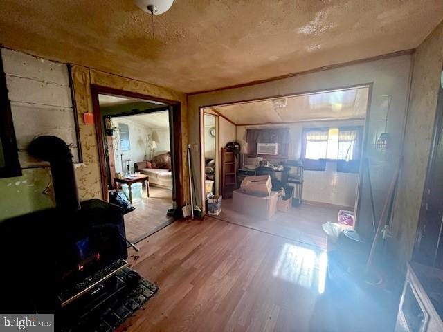 miscellaneous room featuring hardwood / wood-style floors, a textured ceiling, and a wood stove