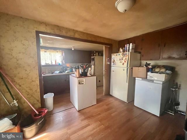 kitchen with hardwood / wood-style floors and white fridge